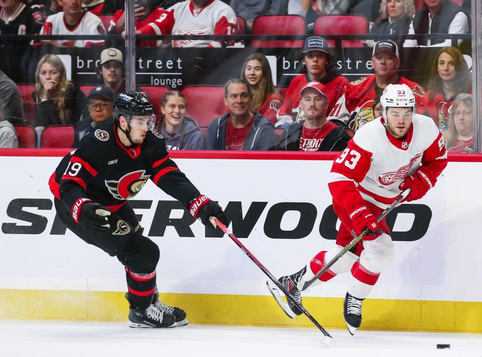 Red Wings forward Alex DeBrincat skates with the puck against the Senators' Drake Batherson in the first period on Saturday, Oct. 21, 2023, in Ottawa.