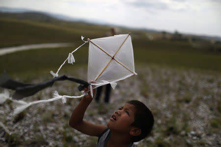 A Venezuelan indigenous boy of Pemon tribe flies a kite at the Brazilian indigenous village Tarau Paru in the border city of Pacaraima, Brazil April 12, 2019. Picture taken April 12, 2019. REUTERS/Pilar Olivares