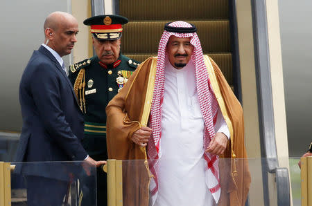 Saudi Arabia's King Salman (R) stands on an escalator as he arrives at Halim Perdanakusuma airport in Jakarta, Indonesia March 1, 2017. REUTERS/Beawiharta