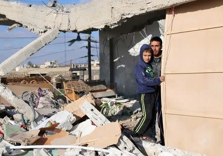 Civilians stand in a damaged house after an airstrike in the rebel-held southern town of Bosra al-Sham, Deraa Governorate, Syria February 17, 2017. REUTERS/Alaa Al-Faqir