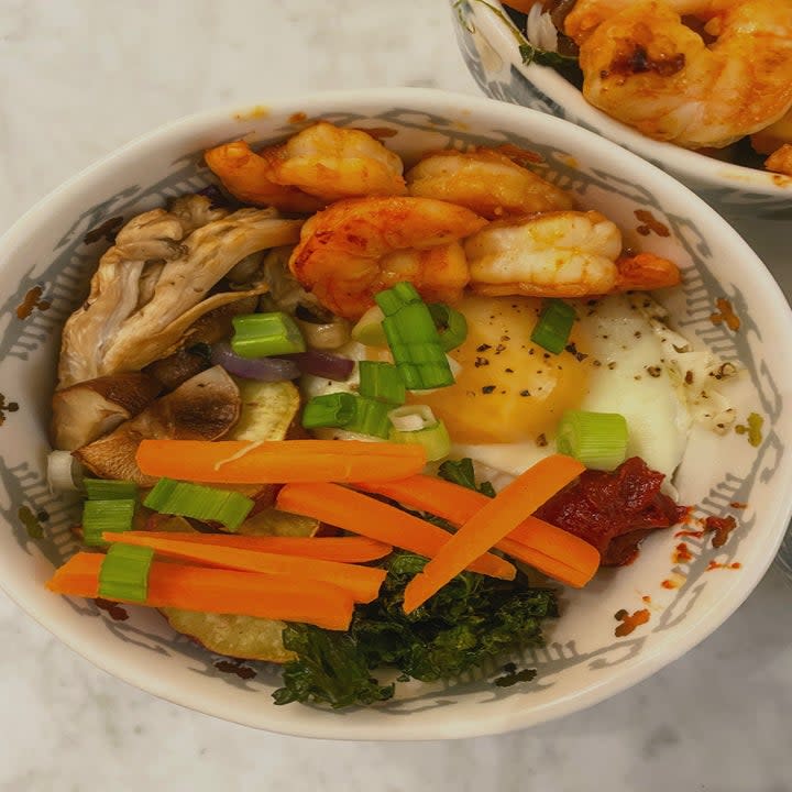 A bibimbap bowl with an egg and shrimp