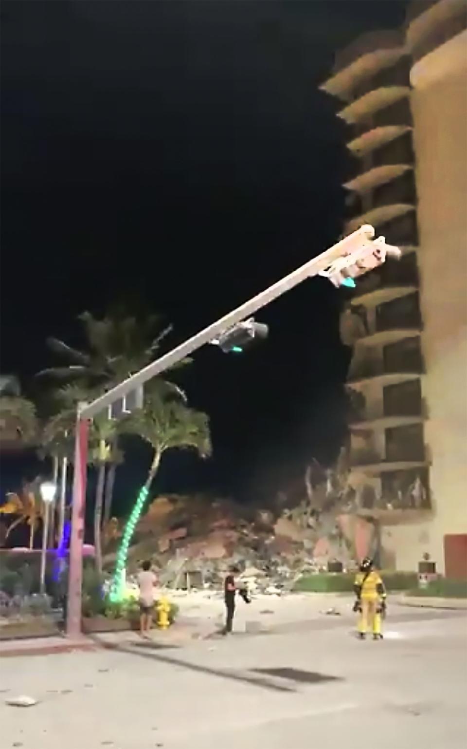 In this image made from video, officials arrive on the scene of a building collapse in Surfside, Miami, Fla., early Thursday, June 24, 2021.