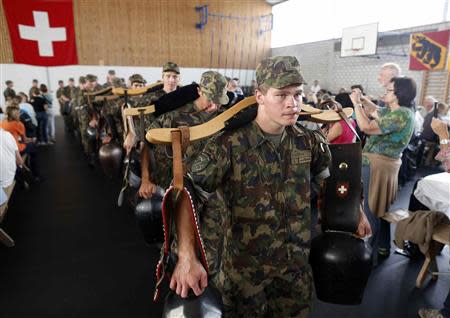 Recruits from the veterinary troops of the Swiss Army play traditional cow-bells during an official visiting day at a Swiss army base in Sand bei Schoehnbuehl, outside Bern September 7, 2013. REUTERS/Ruben Sprich