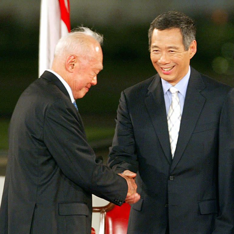 Singapore’s founding father Lee Kuan Yew congratulates his son, Prime Minister Lee Hsien Loong, after the latter took his oath of office at the Istana palace on August 12, 2004.<span class="copyright">Roslan Rahman—AFP/Getty Images</span>