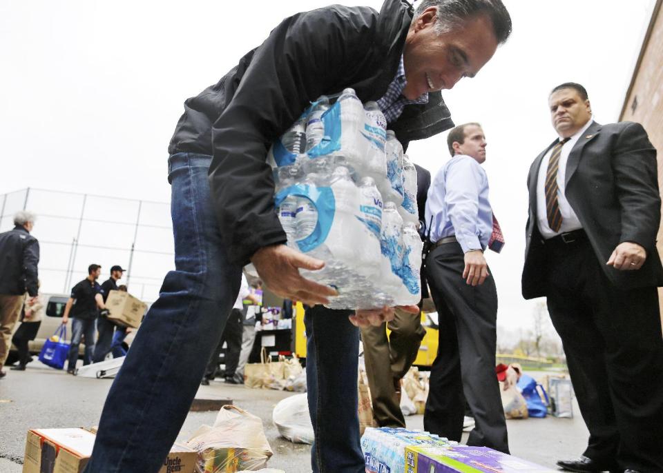 Republican presidential candidate, former Massachusetts Gov. Mitt Romney lifts bottles of water to load into a truck as he participates in a campaign event collecting supplies from residents and local relief organizations for victims of superstorm Sandy,Tuesday, Oct. 30, 2012, at the James S. Trent Arena in Kettering, Ohio. (AP Photo/Charles Dharapak)