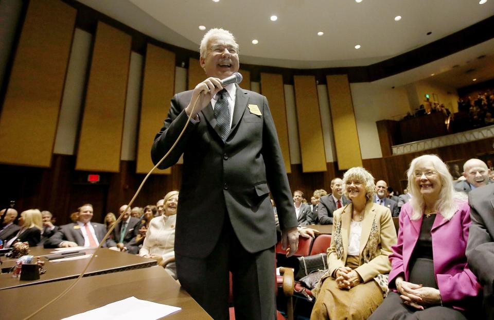 FILE - In this Jan. 13, 2014 file photo Rep. John Kavanagh, R-Fountain Hills, smiles as he addresses the legislature in the Arizona House of Representatives at the Arizona Capitol, in Phoenix. Republicans in the Arizona Legislature are reacting to last year's wave of damage to Confederate monuments by civil rights protesters here and across the nation by working to make it a felony to damage or destroy any public or private monument or statue. Kavanagh supported his position at a Senate committee hearing Thursday, March 25, 2021, by saying public monuments are a statement by the community that demands more protection. (AP Photo/Ross D. Franklin, File)