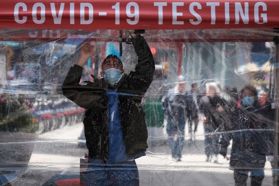 <div class="inline-image__caption"><p>A man adjusts a COVID testing tent in Times Square on April 27.</p></div> <div class="inline-image__credit">Spencer Platt/Getty</div>