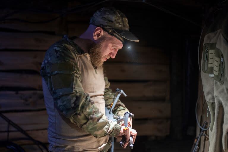 Un militar ucraniano de la unidad 9.2, apodado Mamay, coloca una bomba en un dron en las trincheras en el frente, a unos kilómetros de Bakhmut, en la región de Donetsk, Ucrania (AP Foto/Alex Babenko)