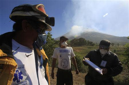 Rescue workers monitor the activity of the Chaparrastique volcano in the municipality of San Miguel December 30, 2013. REUTERS/Ulises Rodriguez