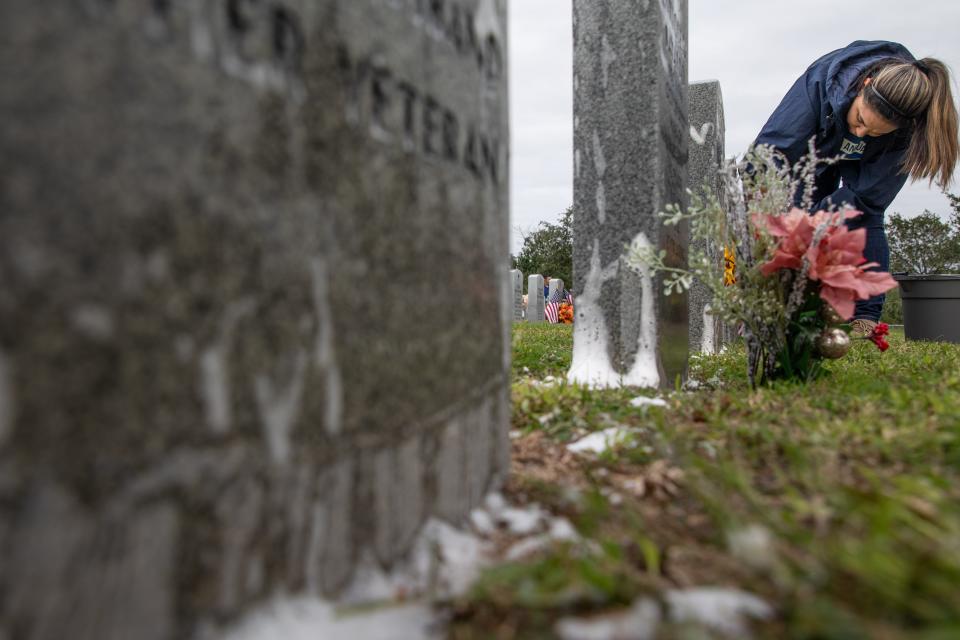 Bianca Enrriques cleans a row of headstones with soapy water at the Coastal Bend Veteran's Cemetery on Tuesday, Nov. 28, 2023, in Corpus Christi, Texas. Enrriques said this was her second year volunteering with fellow TAMUCC staff to clean headstones.