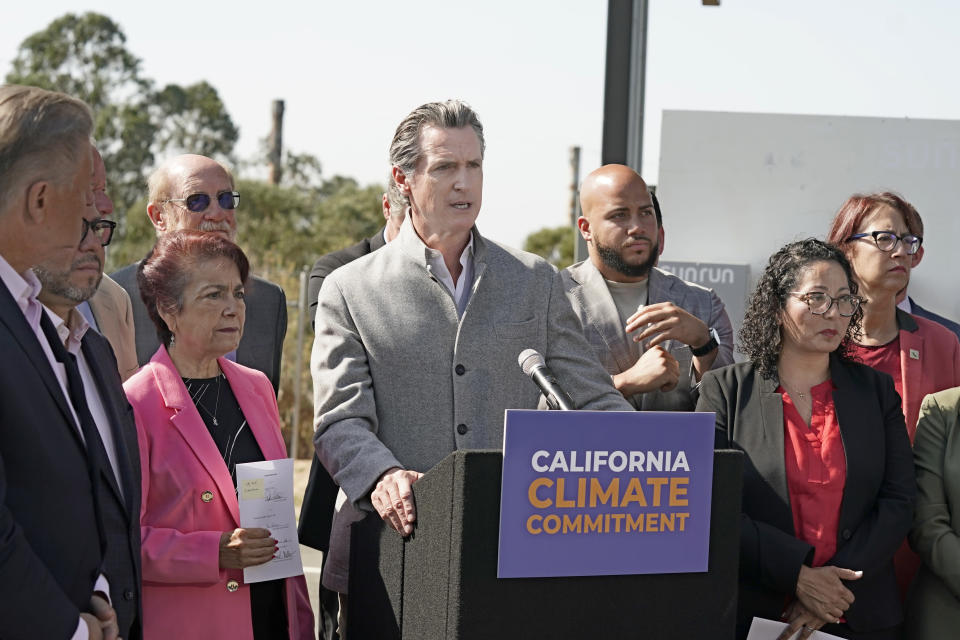 Gov. Gavin Newsom, center, flanked by state lawmakers discusses the package of legislation he signed that accelerates the climate goals of the nation's most populous state, at Mare Island in Vallejo, Calif., Friday, Sept. 16, 2022. (AP Photo/Rich Pedroncelli)