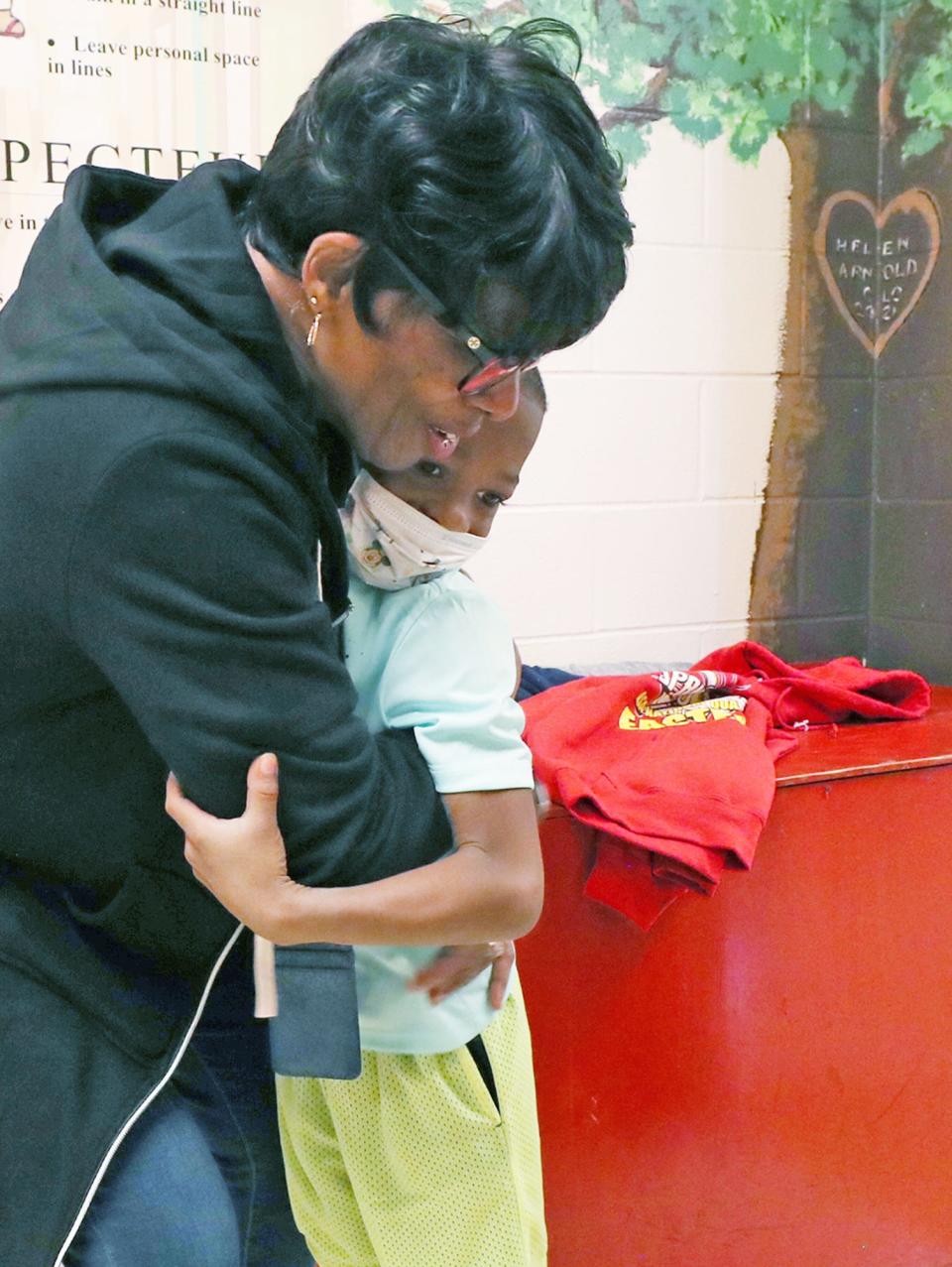 Helen Arnold first grade teacher Denise Williams hugs her former student Tyren Thompson, 7, in the hallway when he returned to the school for a visit after he was shot following a pee wee football game.
