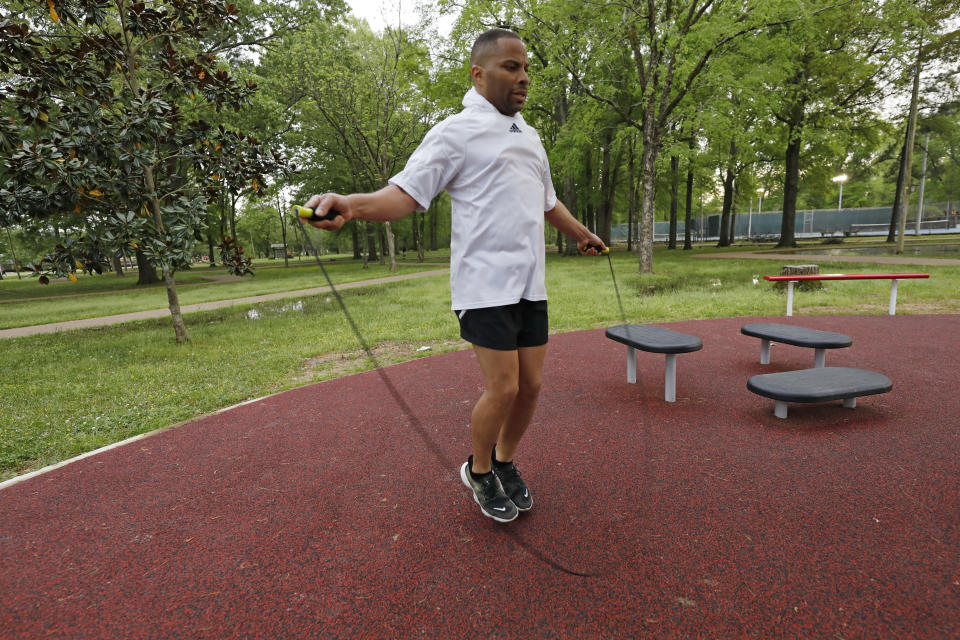 Tommy Laster, 48, uses a boxer's cadence as he skips rope following an afternoon run, Monday, March 23, 2020, in Jackson, Miss. Runners across the country are still hitting the pavement and the trails, staying fit and working off some stress amid the coronavirus pandemic. (AP Photo/Rogelio V. Solis)