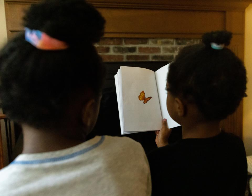 One of the foster children in the Seavers' Marstons Mills home opens to the last page of the book “Jack & Max & The Happy Home,” which shows a butterfly symbolizes change, hope and new life. The girl on the left is 10 years old and the one on the right is 6.