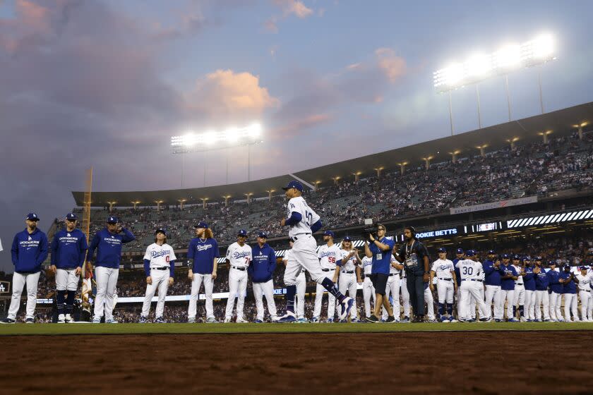 Dodgers right fielder Mookie Betts jogs past the rest of the team as he is introduced before game one of the NLDS