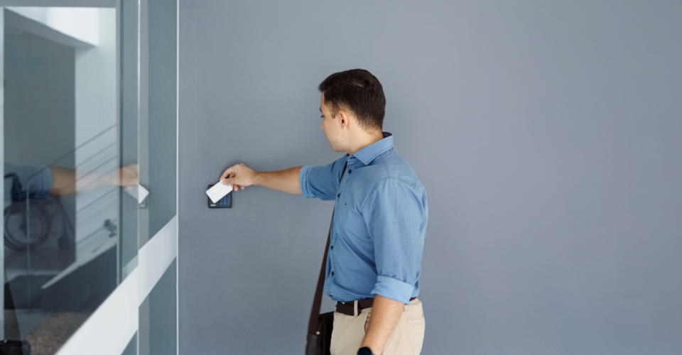 Young man using security key card scanning to open the door to enter office building