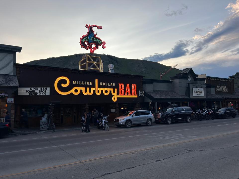 Wealthy patrons sip beers while straddling saddles at a Wyoming bar called The Million Dollar Cowboy.