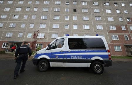 A German police officer walks outside a building, that also serves as an accommodation facility for refugees, in the village of Suhl, Germany, October 25, 2016. REUTERS/Kai Pfaffenbach