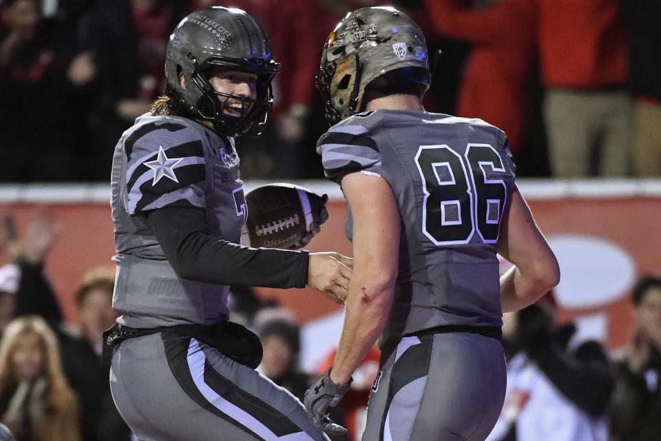 Utah quarterback Cameron Rising, left, celebrates his touchdown with Dalton Kincaid (86) during the first half of an NCAA college football game against Oregon on Saturday, Nov. 20, 2021, in Salt Lake City. (AP Photo/Alex Goodlett)