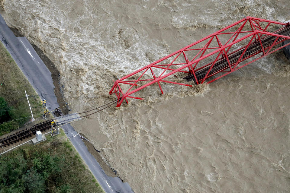 A collapsed railway bridge is seen over the Chikuma river swollen by Typhoon Hagibis in Ueda, Nagano prefecture, central Japan, Sunday, Oct. 13, 2019. Rescue efforts for people stranded in flooded areas are in full force after a powerful typhoon dashed heavy rainfall and winds through a widespread area of Japan, including Tokyo.(Kyodo News via AP)