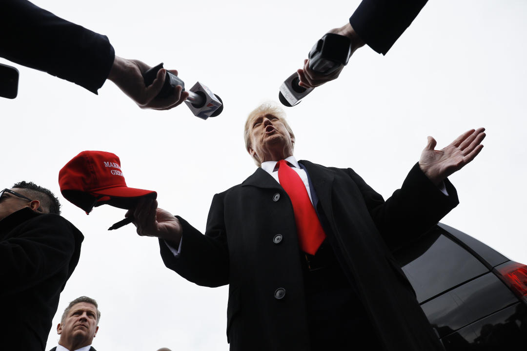 Donald Trump talks to reporters while visiting the polling site at a high school in Londonderry.