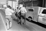 <p>A police officer holds the Rev. Martin Luther King Jr. by his belt as he leads him to the paddy wagon, following arrest at an anti-segregation protest in downtown Birmingham, Ala., on April 13, 1963. An unidentified cameraman is documenting the scene. (AP Photo) </p>