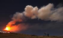 A photographer takes pictures of Italy's Mount Etna, Europe's tallest and most active volcano, spewing lava as it erupts on the southern island of Sicily November 17, 2013. There were no reports of damage or evacuations in the area and the nearby airport of Catania was operating as normal, local media reported. It is the 16th time that Etna has erupted in 2013. The south-eastern crater, formed in 1971, has been the most active in recent years. REUTERS/Antonio Parrinello (ITALY - Tags: ENVIRONMENT SOCIETY TPX IMAGES OF THE DAY)