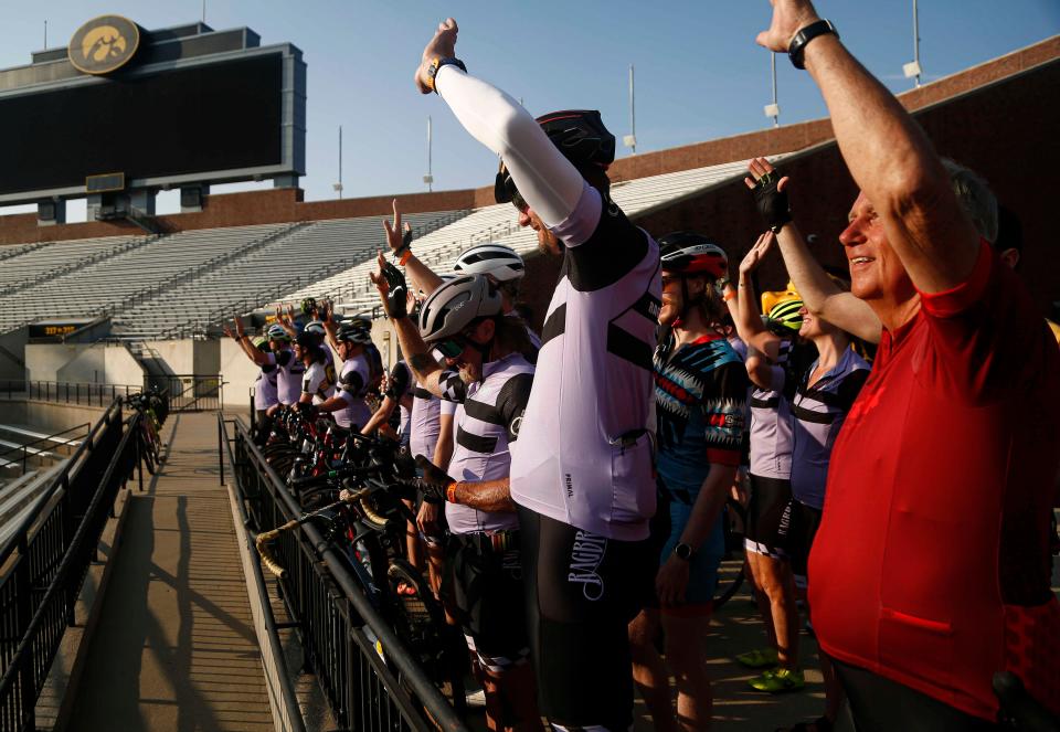 Cyclists wave to University of Iowa Children’s Hospital from Kinnick Stadium during the final day of the RAGBRAI route inspection ride Saturday.