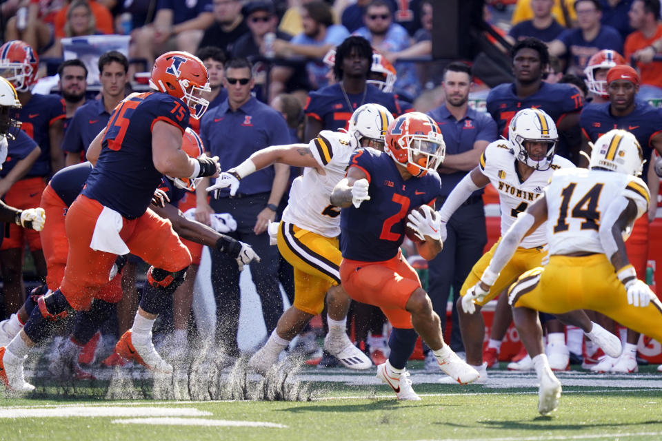 Illinois running back Chase Brown (2) carries the ball during the first half of an NCAA college football game against Wyoming, Saturday, Aug. 27, 2022, in Champaign, Ill. (AP Photo/Charles Rex Arbogast)