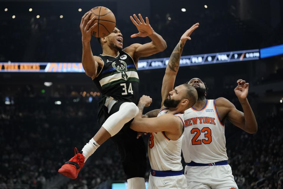 Milwaukee Bucks' Giannis Antetokounmpo is fouled by New York Knicks' Evan Fournier during the first half of an NBA basketball game Friday, Jan. 28, 2022, in Milwaukee. (AP Photo/Morry Gash)