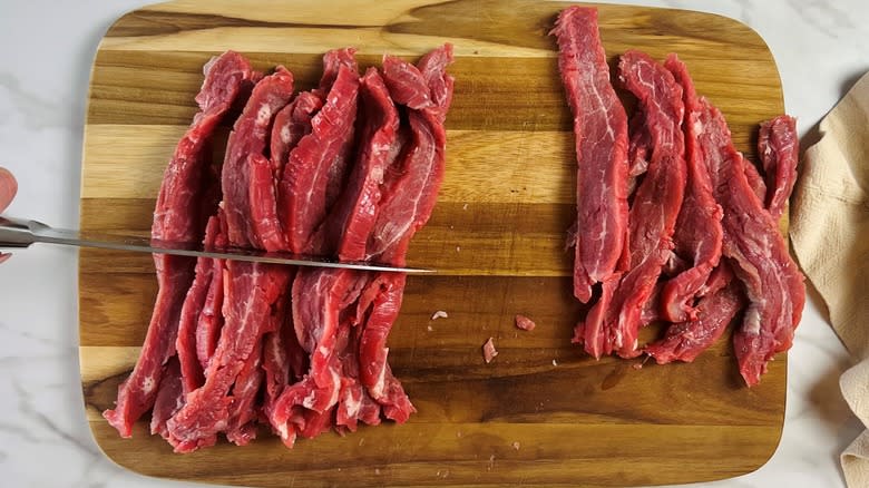 sliced raw flank steak on cutting board