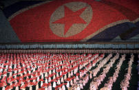 FILE - In this July 22, 2013, file photo, North Korean women dance in front of a display of their country's national flag in Pyongyang, North Korea. North Korea is bringing back one of its most iconic art forms - mass games performed by tens of thousands of people working in precise unison - to mark its 70th anniversary on Sunday, Sept. 9, 2018. The performance, which takes months if not years of intense preparation and training, is being called “Glorious Country” this year. (AP Photo/Wong Maye-E)