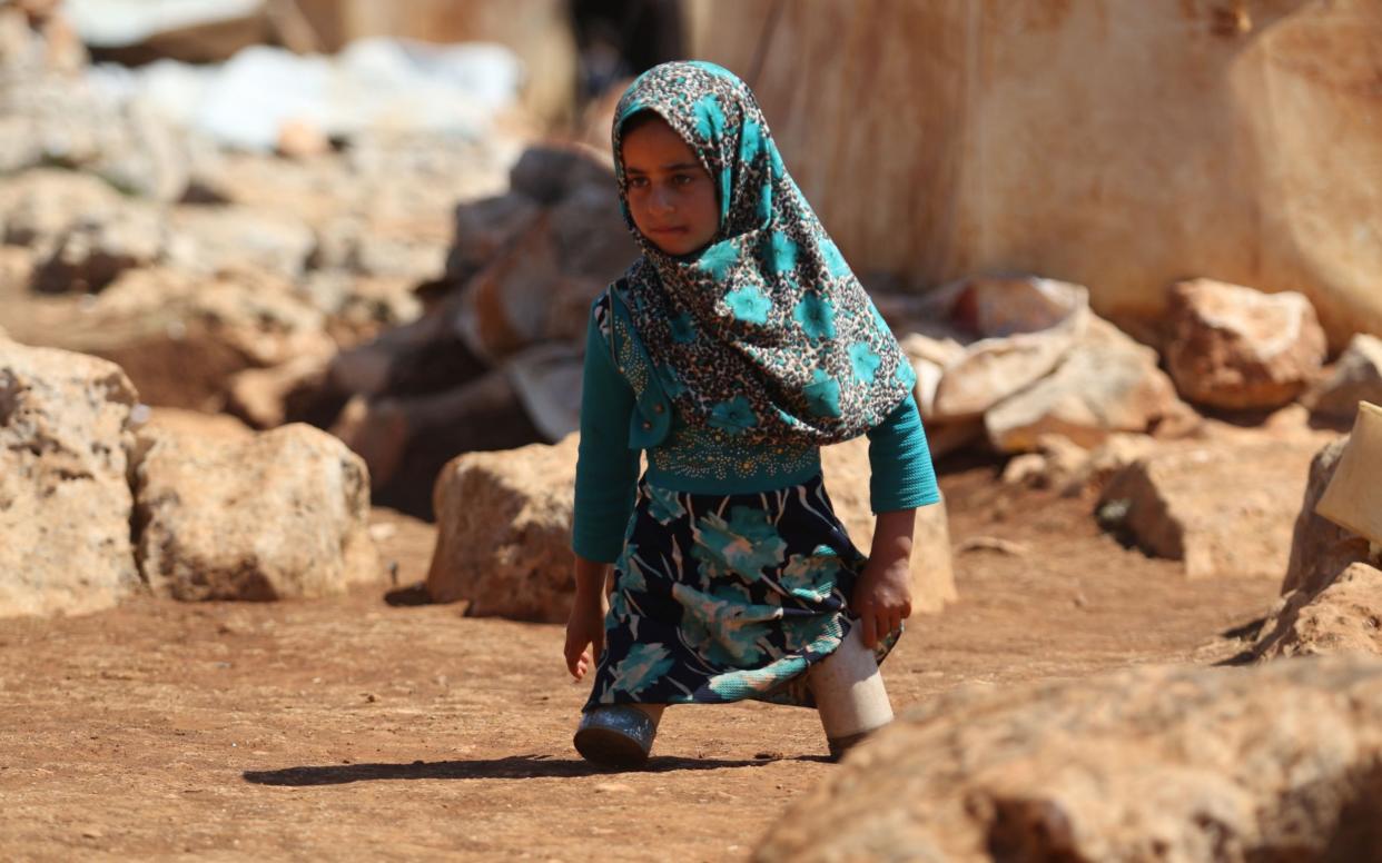 Eight year-old Maya walks in a camp for displaced people in Syria on June 20 - AFP