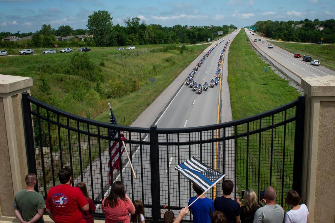 People watch from an overpass along U.S. 169 Hwy as the funeral procession for North Kansas City police officer Daniel Vasquez approaches Wednesday, July 27, 2022, in Kansas City. Vasquez was shot and killed while on duty last week in North Kansas City.