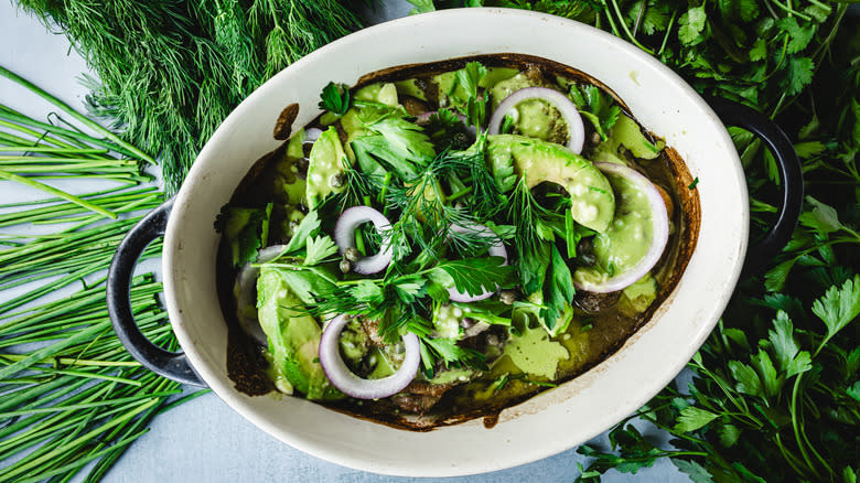 Chicken casserole dish surrounded by herbs