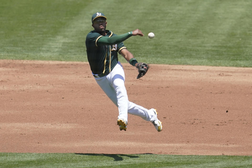 Oakland Athletics shortstop Elvis Andrus throws to first base on a single hit by Texas Rangers' Nick Solak during the second inning of a baseball game in Oakland, Calif., Thursday, July 1, 2021. (AP Photo/Jeff Chiu)