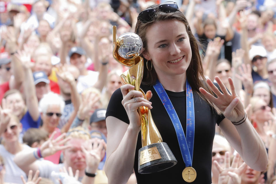 Rose Lavelle with the World Cup trophy holding four fingers.