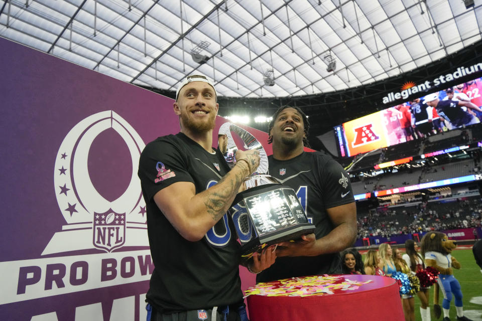 NFC tight end George Kittle, left, of the San Francisco 49ers, and defensive end Cameron Jordan of the New Orleans Saints hold the trophy after the NFC defeated AFC at the NFL Pro Bowl games, Sunday, Feb. 5, 2023, in Las Vegas(AP Photo/John Locher)