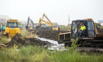 Workers extend a tidal levee 1,300 feet on the back of the island in preparation for Hurricane Delta storm surge in Grand Isle, La., Thursday, Oct. 8, 2020. According to Jefferson Parish Councilman Ricky J. Templet, about 450 truck loads of dirt from Larose were placed on the backside of the levee to protect the heart of the island from flooding, which is also "the bowl" of the island. The tidal levee was connected with an existing 10-year-old levee which covers about 2-miles. (Sophia Germer/The Advocate via AP)