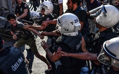 Turkish riot policemen clash with an LGBT rights activist  - Credit: AFP