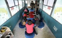 Sudents attend a class inside a bus in the city of al-Bab