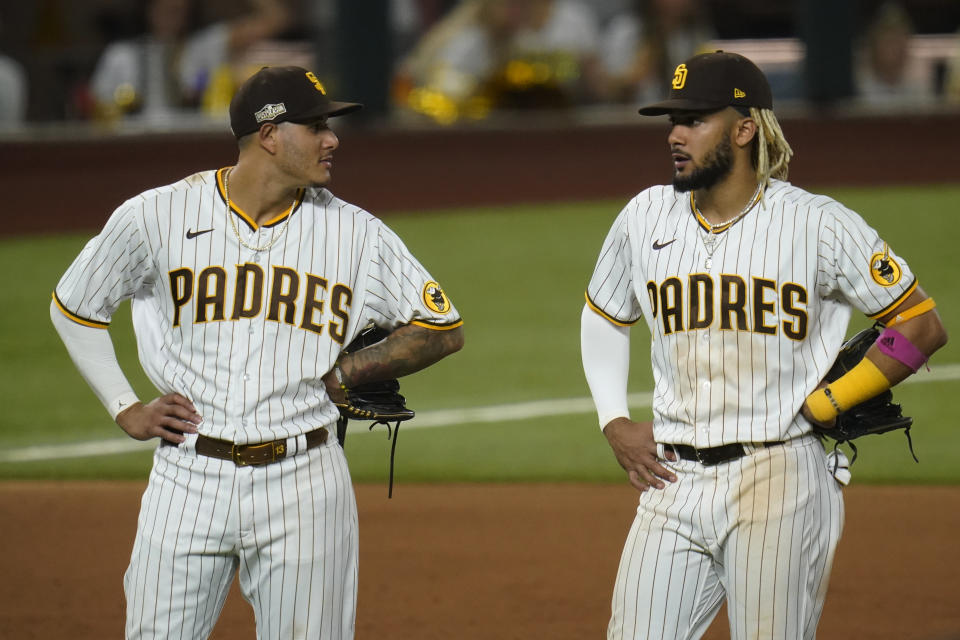 San Diego Padres third baseman Manny Machado, left, and shortstop Fernando Tatis Jr., right, talk in the infield during Game 3 of a baseball National League Division Series against the Los Angeles Dodgers Thursday, Oct. 8, 2020, in Arlington, Texas. (AP Photo/Sue Ogrocki)