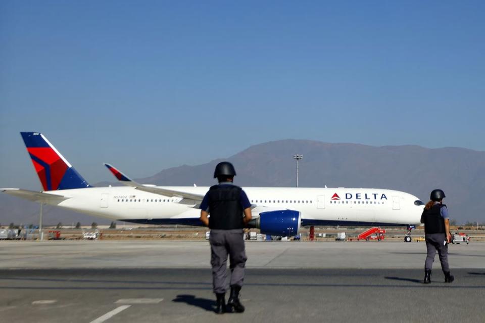 Police officers walk near a Delta Air Lines plane on the tarmac of Santiago's Arturo Merino Benitez International Airport on March 8 (AFP via Getty Images)