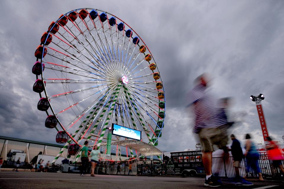 People walk by the Sky Eye Ferris Wheel at the 2019 Oklahoma State Fair.