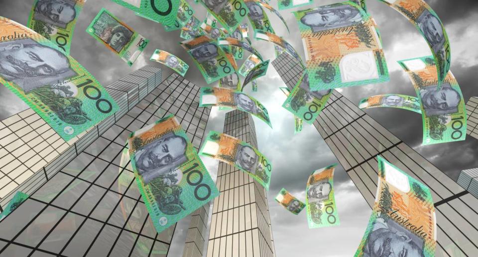 Money falling down in a large city - cost of living is increasing which is causing Aussies to spend more money helping overseas family. Source: Getty Images