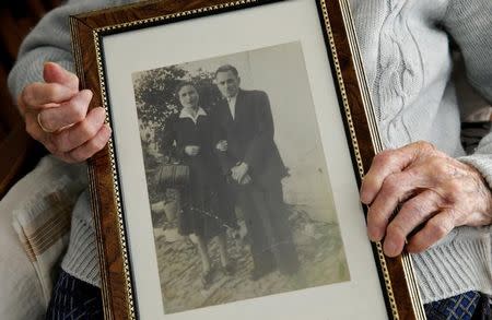 Maria Josefa Guillen, 103, holds a picture of herself with her husband from when they were young, in her home in Cazalla de la Sierra, Seville, southern Spain, September 18, 2016. REUTERS/Andrea Comas/Files