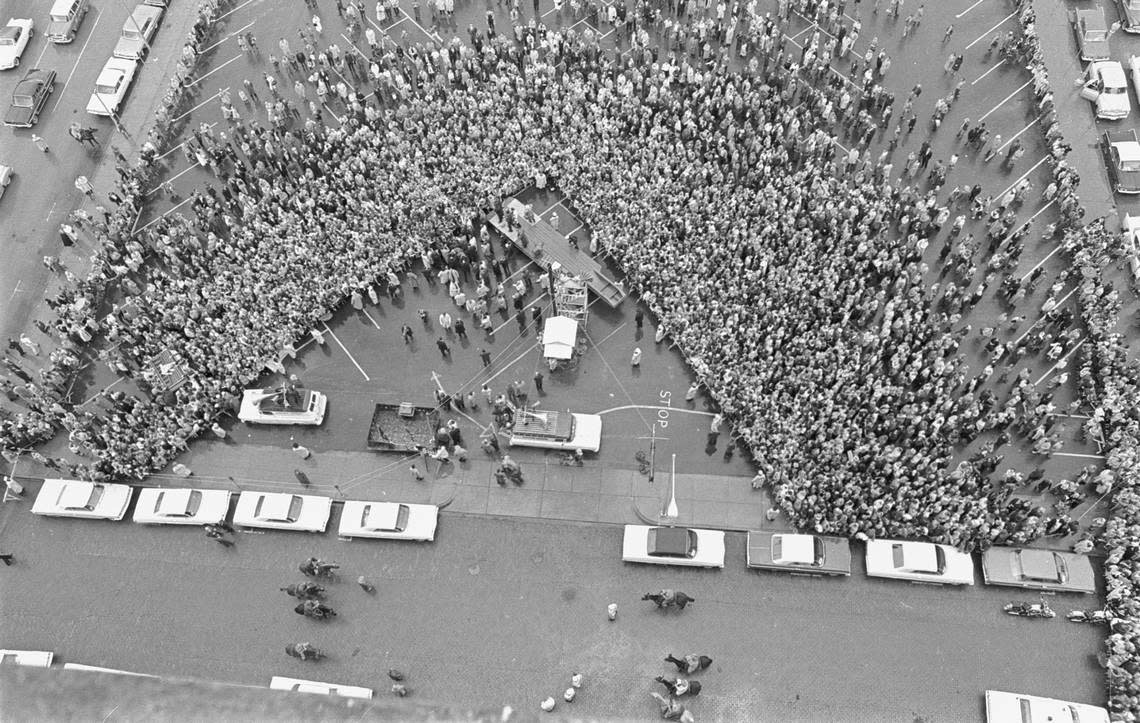 Aerial of crowd waiting to hear John F. Kennedy speak outside Hotel Texas, now the Hilton. A flatbed truck moved in place as a temporary stage. Mounted sheriff’s patrol did crowd control. Fort Worth, 11/22/1963