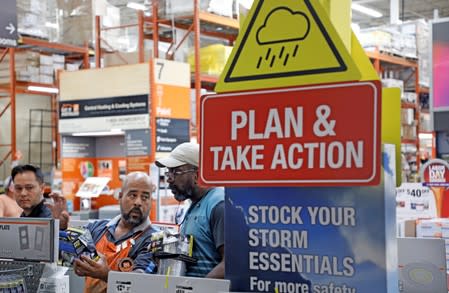 Home Depot worker helps a customer get supplies ahead of the arrival of Hurricane Dorian in Kissimmee