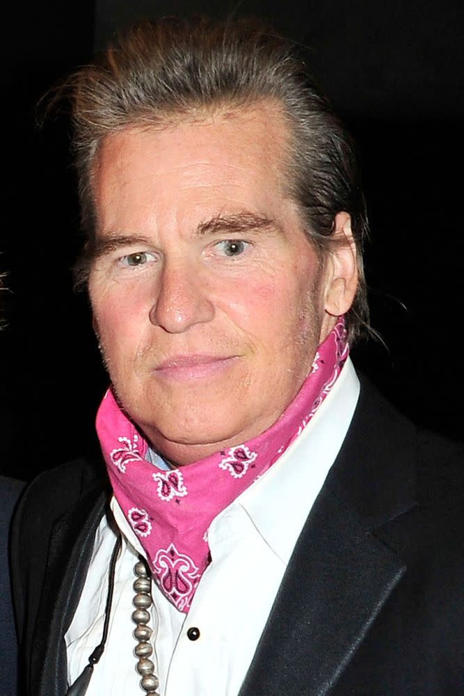 Val Kilmer covering his neck with a scarf in 2015.