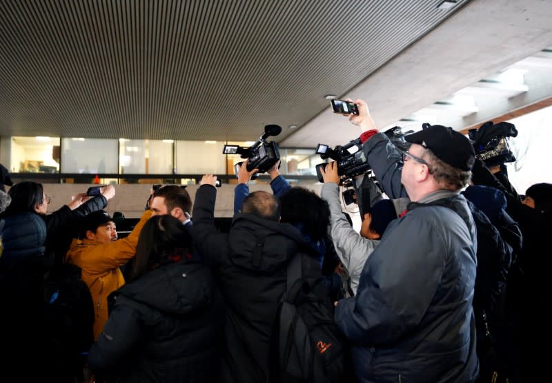 Members of the media crowd around the car of Huawei Chief Financial Officer Meng Wanzhou as she leaves B.C. Supreme Court for a lunch break during the first day of her extradition hearing in Vancouver